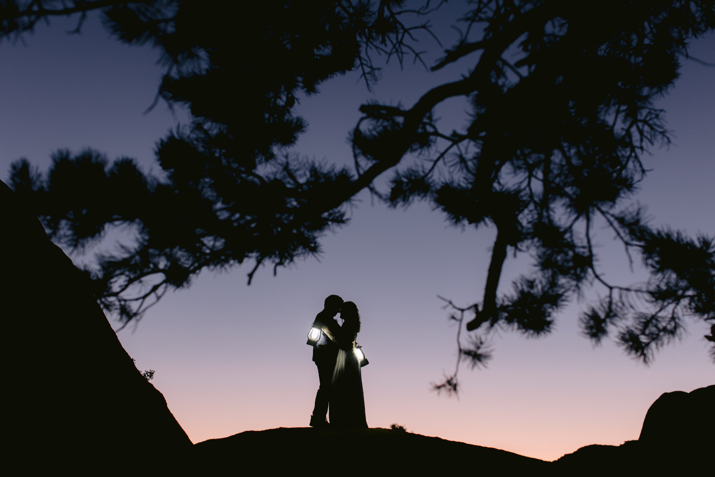 Silohuette of Couple embracing on rocks in desert - image by GunnShot Photography