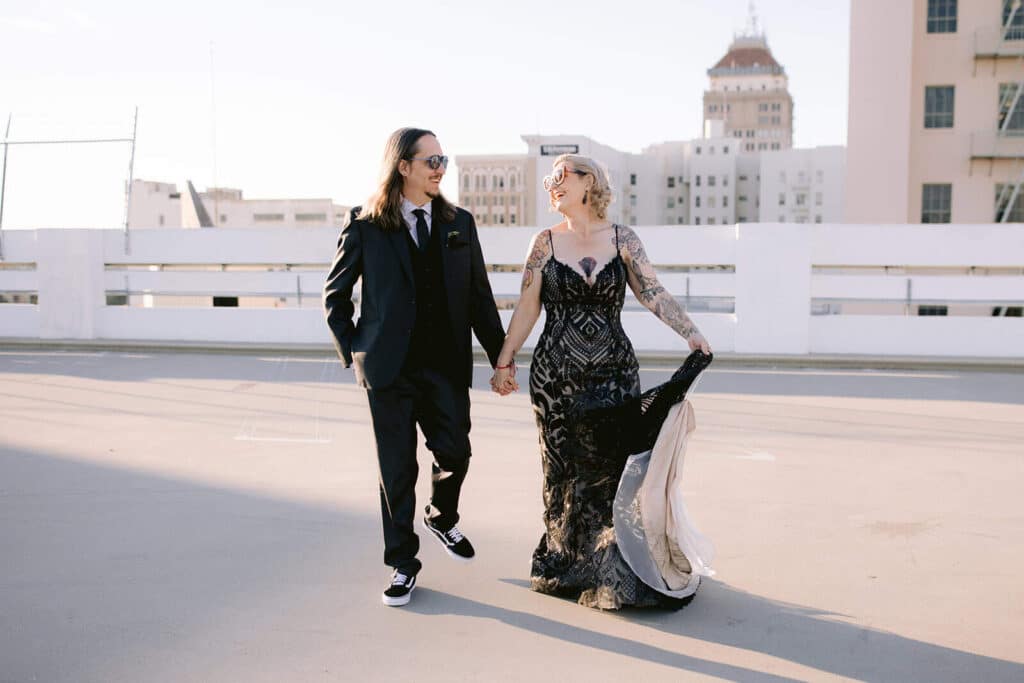 Groom dipping bride on rooftop with Fresno skyline in the background after courthouse wedding