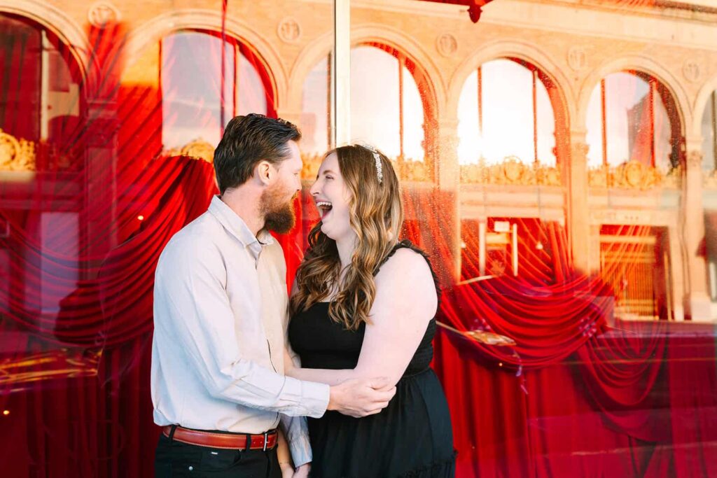 Courthouse wedding couple laughing together in front of red window reflections in Fresno